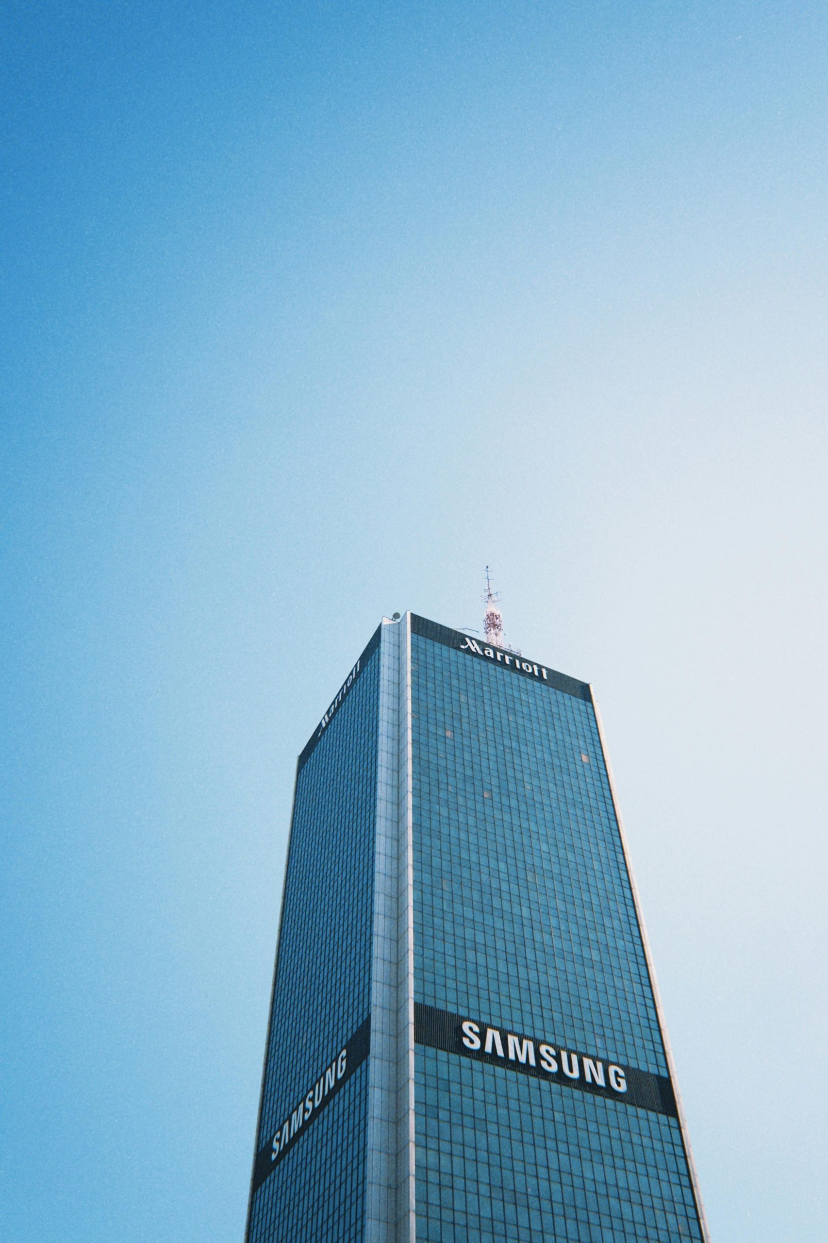 Modern skyscraper in Warsaw against a clear sky, showcasing urban architecture.